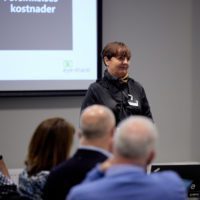 Female eye-share employee smiling at an audience in conference room